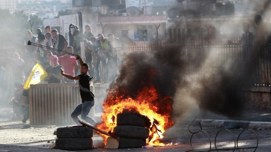 Lanzan piedras hacia las fuerzas de seguridad israelíes durante los enfrentamientos en la entrada principal de la ciudad cisjordana de Belén el 6 de octubre de 2015, tras el funeral de 13 años de edad, Abdel Rahman Abdullah palestina .