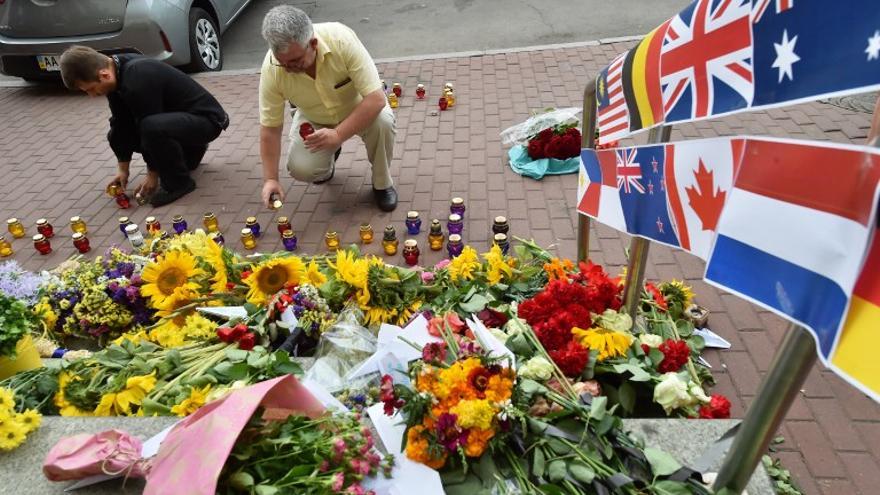 Tras un año de la tragedia del vuelo de Malaysian Airlines, familiares y amigos de las víctimas acuden a una ceremonia de conmemoración y dejan flores fuera de embajada en Kiev.