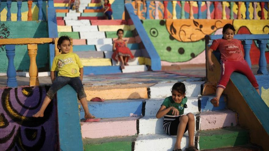 Niños palestinos juegan cerca de la playa en la ciudad de Gaza, sobre una estructura decorada por los niños con la ayuda de la ONG Instituto Tamer para la Educación de la Comunidad.