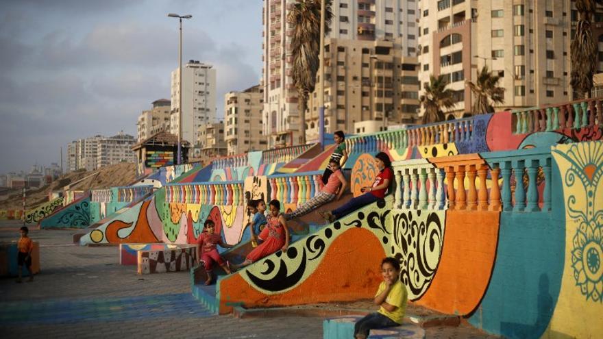 Niños palestinos juegan cerca de la playa en la ciudad de Gaza, sobre una estructura decorada por los niños con la ayuda de la ONG Instituto Tamer para la Educación de la Comunidad.