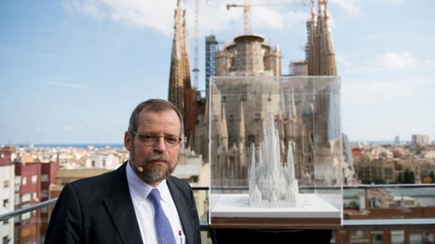 El arquitecto Jordi Faulí posa junto a una réplica y el fondo se observa La Sagrada Familia de Gaudí, en Barcelona