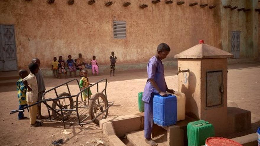 Foto ilustrativa: Un niño trata de abastecerse de agua en Mali