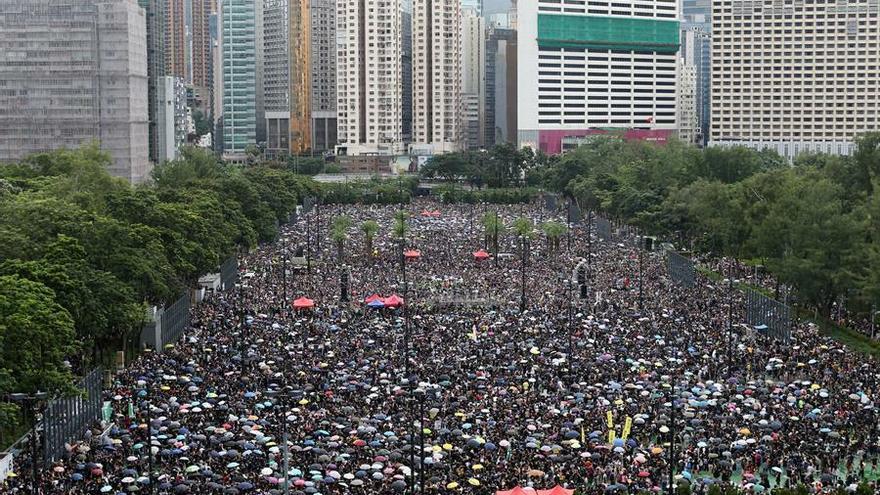 Una multitud se refugia de la lluvia bajo paraguas durante una nueva marcha contra el gobierno en Hong Kong, China.