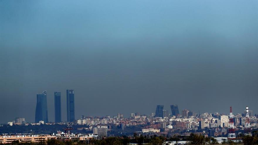 Vista de Madrid con el parque empresarial de las Cuatro Torres, en el Paseo de la Castellana de Madrid, y las Torres Kio, cubiertas por una 'boina' de contaminación.