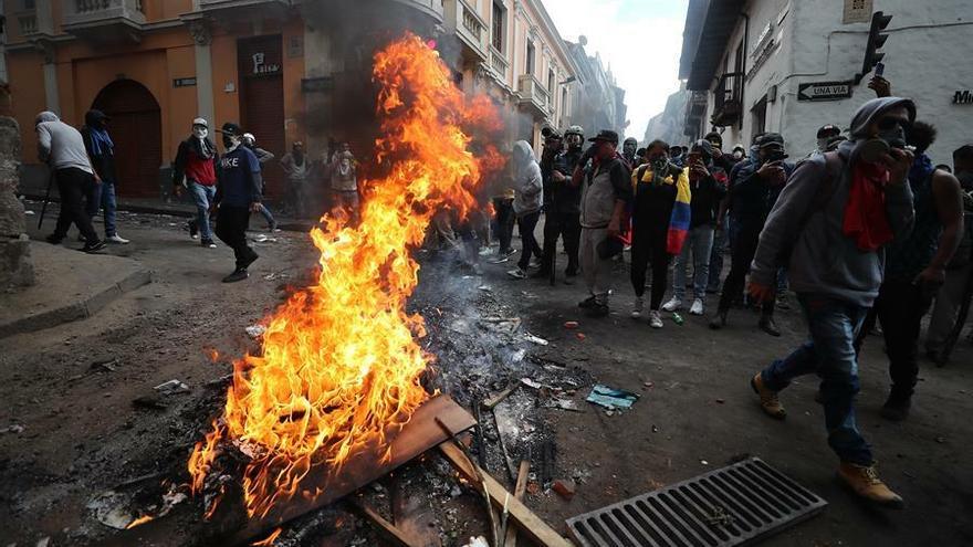 Manifestantes forman una barricada con fuego durante enfrentamientos con la policía este miércoles, en el centro de Quito (Ecuador).