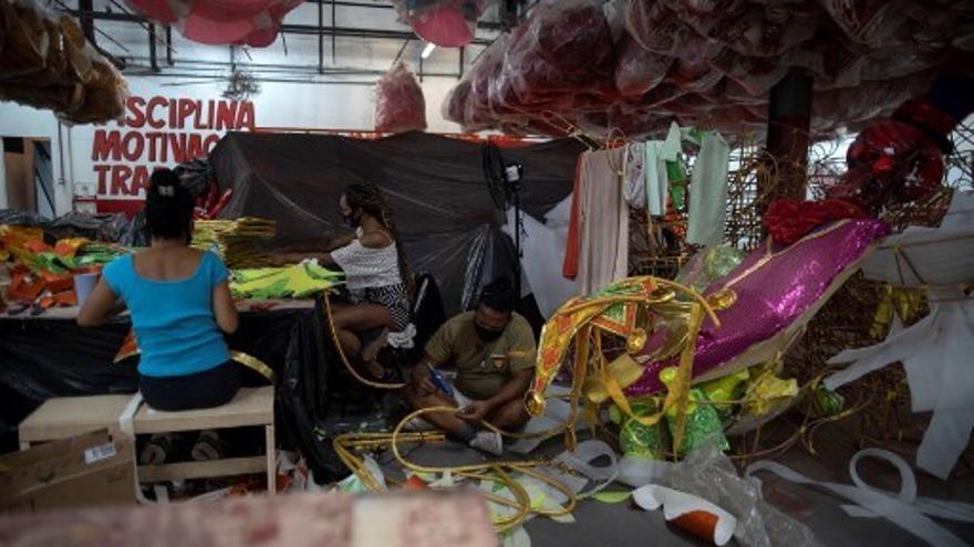 Personas trabajan en disfraces y aparejos en un taller de una escuela de samba