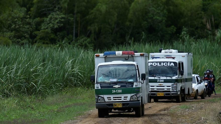 Vehículos de la policía transportan los cadáveres de cuatro personas asesinadas en  Guachinte, Colombia.