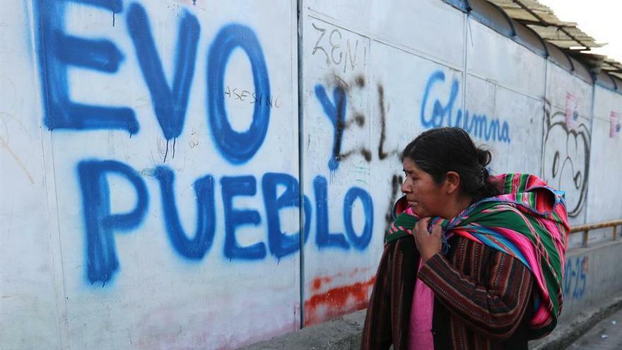 Una mujer camina frente a una pintada en apoyo al presidente Evo Morales en La Paz.