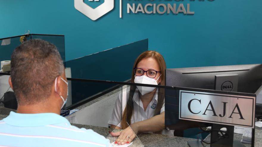 Personal del Banco Hipotecario Nacional atendiendo a un cuentahabiente