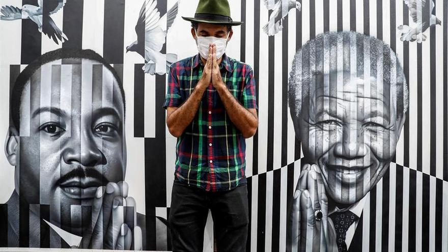 El pintor callejero brasileño Eduardo Kobra posa para Efe junto a una de sus obras tras una entrevista en su taller, el 19 de noviembre de 2020 en la ciudad de Sao Paulo.