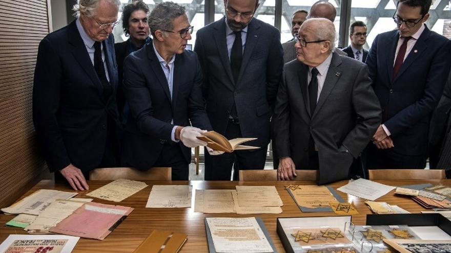 Personas observan documentos históricos en el  Memorial de la Shoah