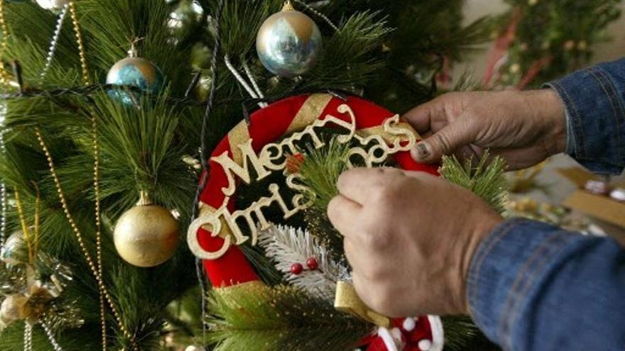 Una persona se dispone a quitar los adornos de su árbol de Navidad